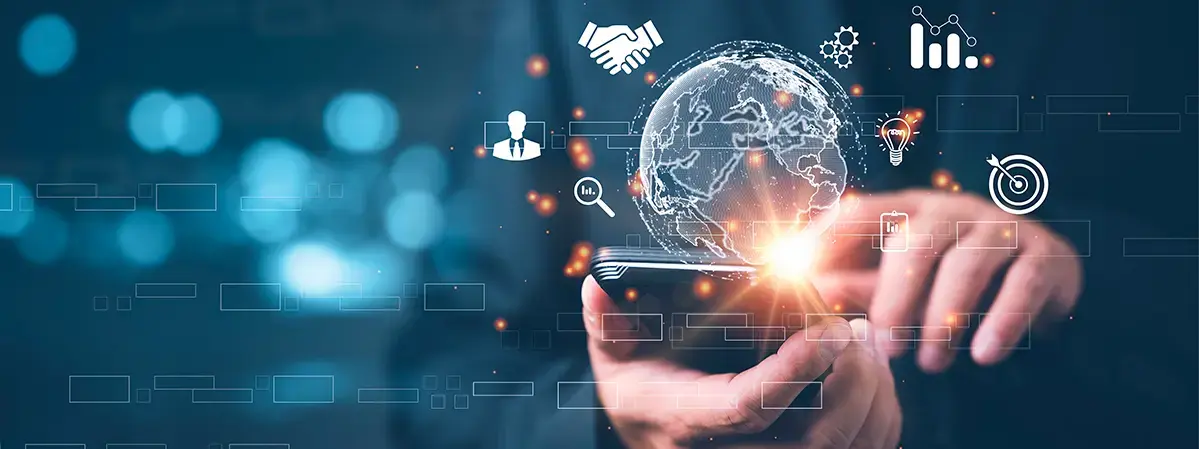 Mano interactuando con un teléfono inteligente, con gráficos digitales, íconos de negocios y un holograma de un globo terráqueo iluminado.